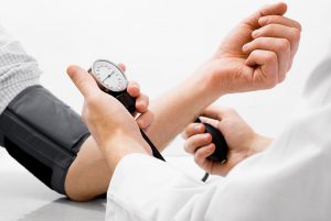 Doctor measuring blood pressure - studio shot on white background